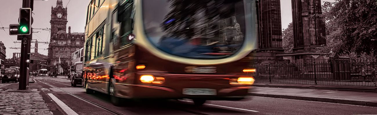 A public bus driving through busy city traffic, highlighting the risk of bus accidents and claims.