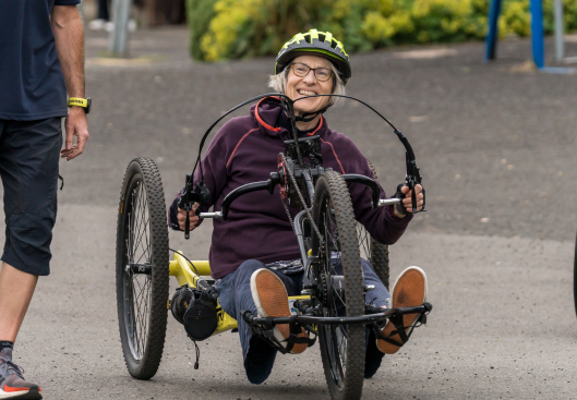 Woman hand cycling at 2024 SIS BBQ