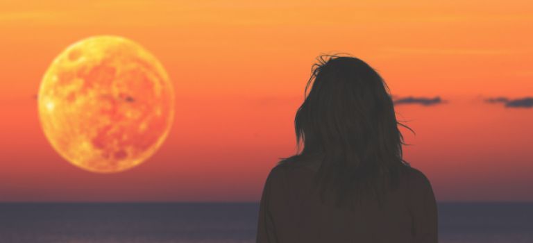 woman looking out to sea at sunset