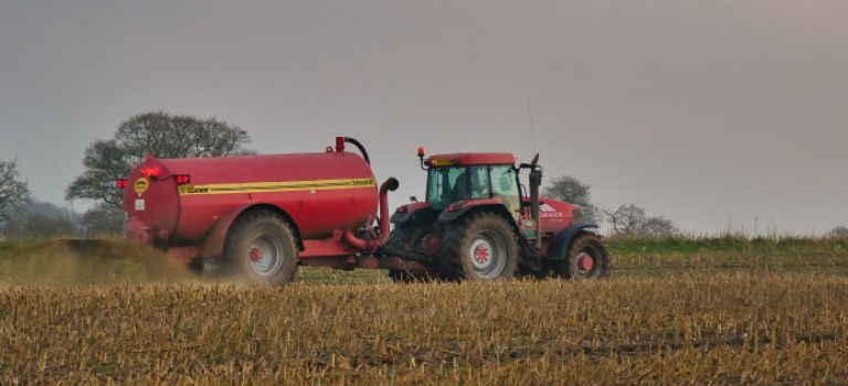 Tractor and muck spreader on farm