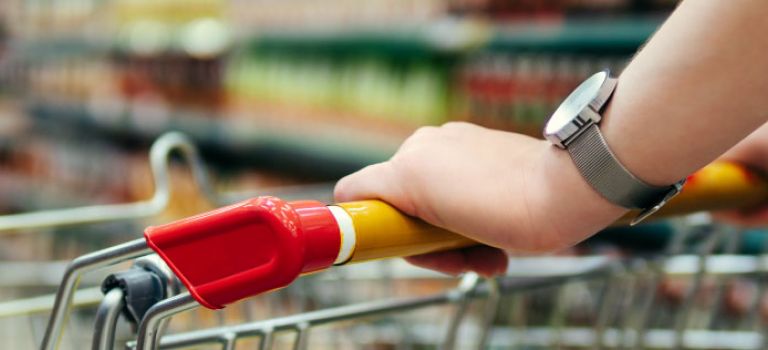 Shopping in supermarket pushing trolley