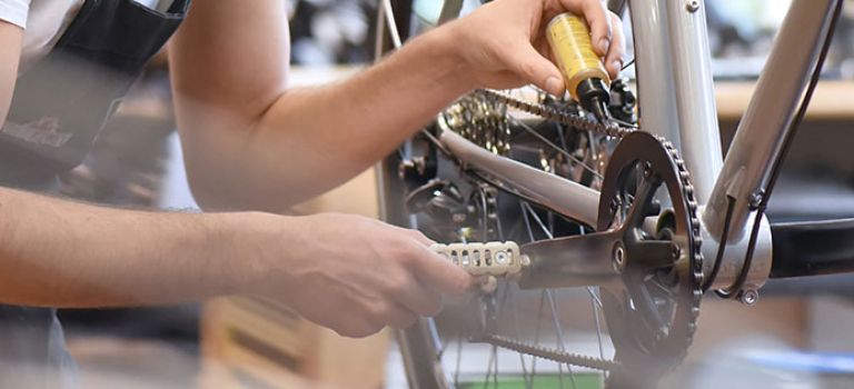 Bike mechanic working on chain