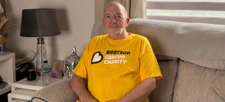 Joe Smith sitting in his home on a couch