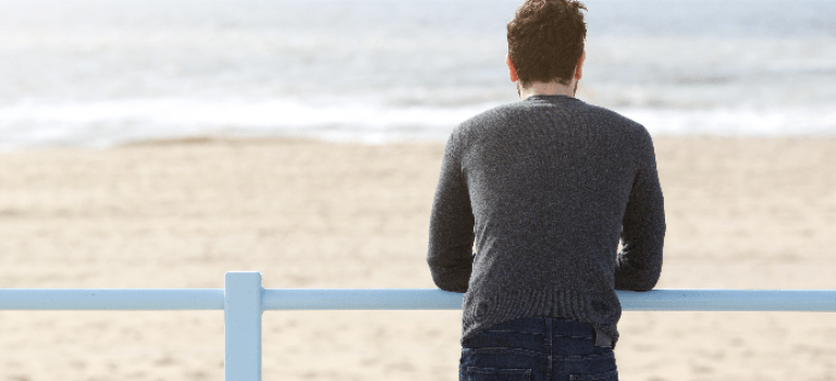 Man standing and looking out to sea